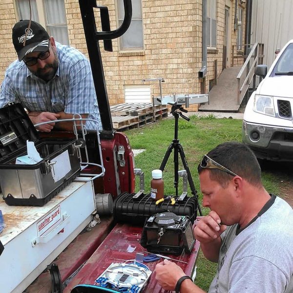 Matt Smith and Travis Ridgeway are resplicing a fiber optic line for the First Baptist Church in Carnegie